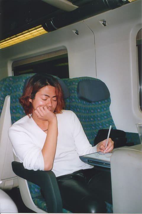 Me asleep over a notebook on a train, working.